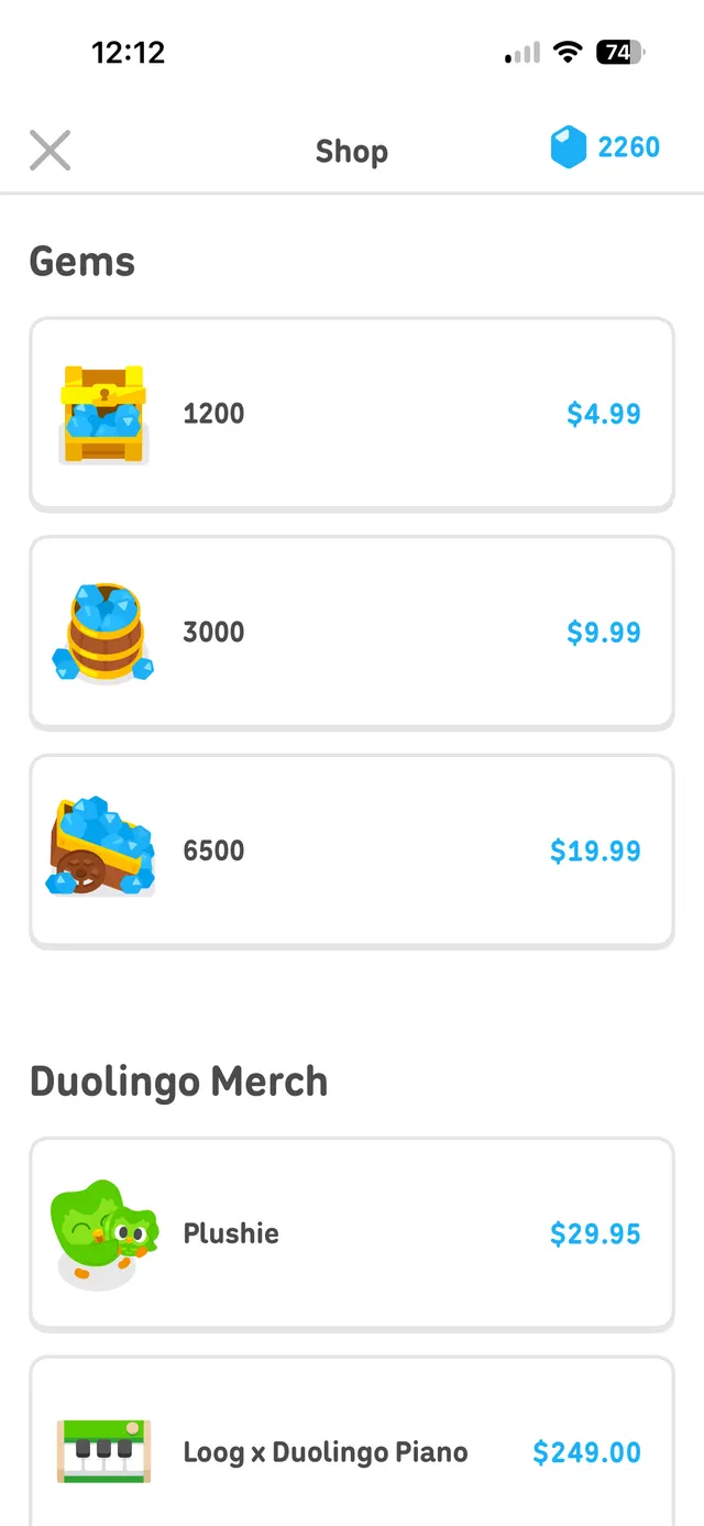 Mobile in-app shop screen showing purchasable gem bundles and Duolingo merch items in stacked cards with prices, with a close button at top left and a gem balance at top right.