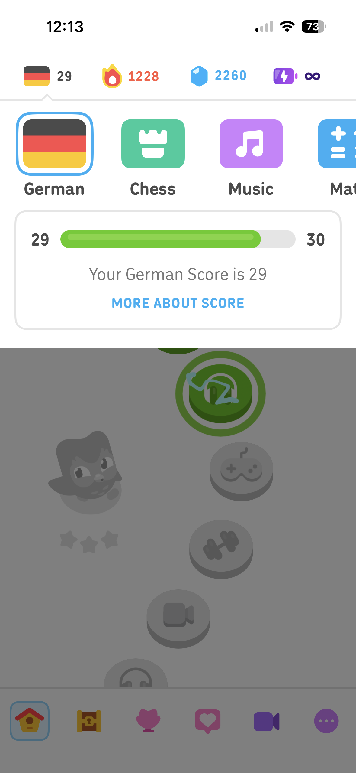 Mobile app screen showing a selected German language course with score progress, skill icons, and a bottom navigation bar.