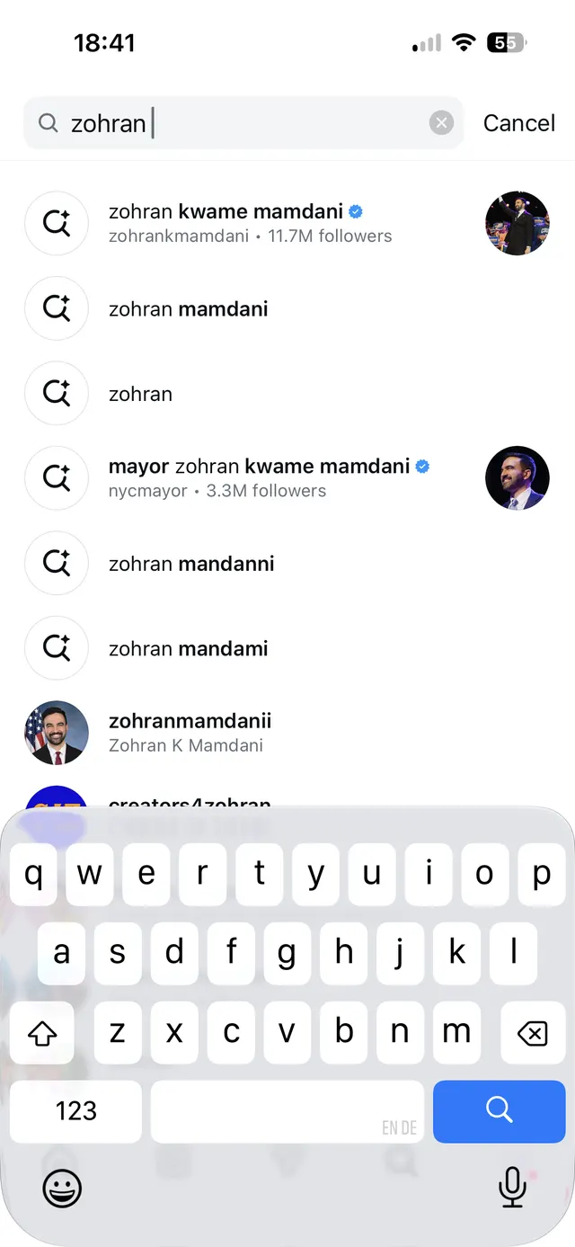 An iOS app search screen with the query "zohran" typed into the search bar, showing a list of suggested people accounts with profile photos, verified badges, follower counts, and the on-screen keyboard open.