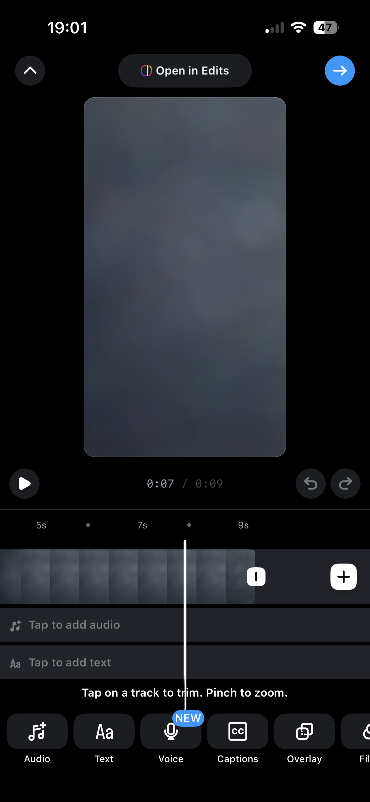 A mobile video editing screen with a preview canvas, play controls, a scrubber timeline with clips, and editing tools like audio, text, voice, captions, and overlay.