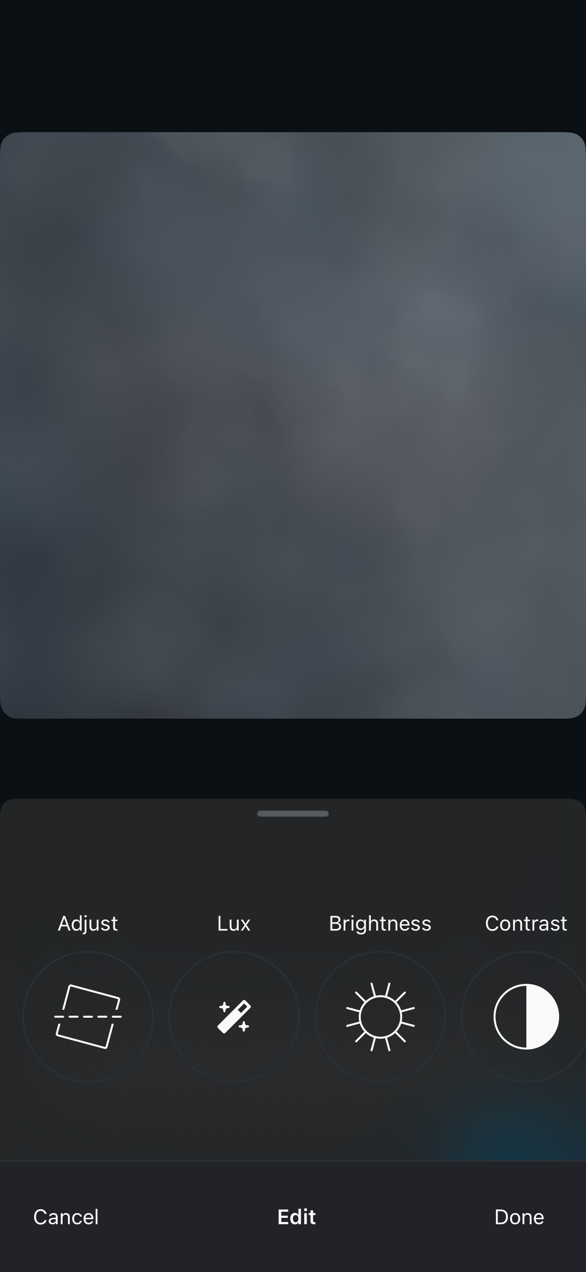 Dark photo editing interface with a large image preview on top and a bottom sheet showing circular tool buttons for Adjust, Lux, Brightness, and Contrast, plus Cancel, Edit, and Done actions.