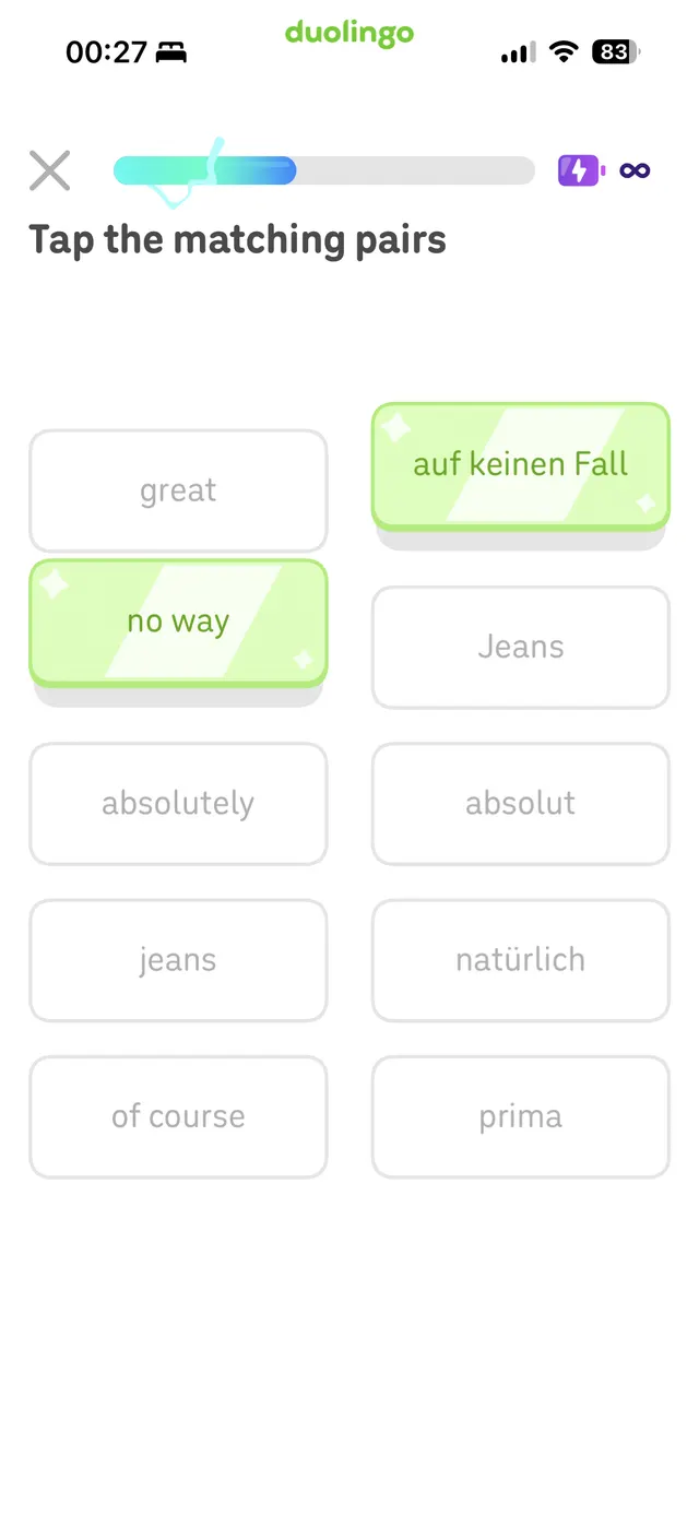 Duolingo lesson screen prompting the user to tap matching word pairs, with several rounded word tiles arranged in two columns and two tiles already matched in green.
